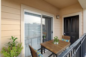 A private fenced-in patio with a storage closet and sliding glass door.